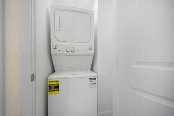 A stacked white washer and dryer set in an apartment 
